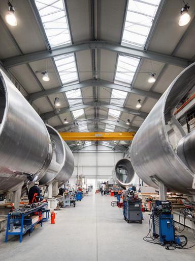 Interior de taller metalúrgico con estructuras de aerogeneradores en proceso de ensamblaje